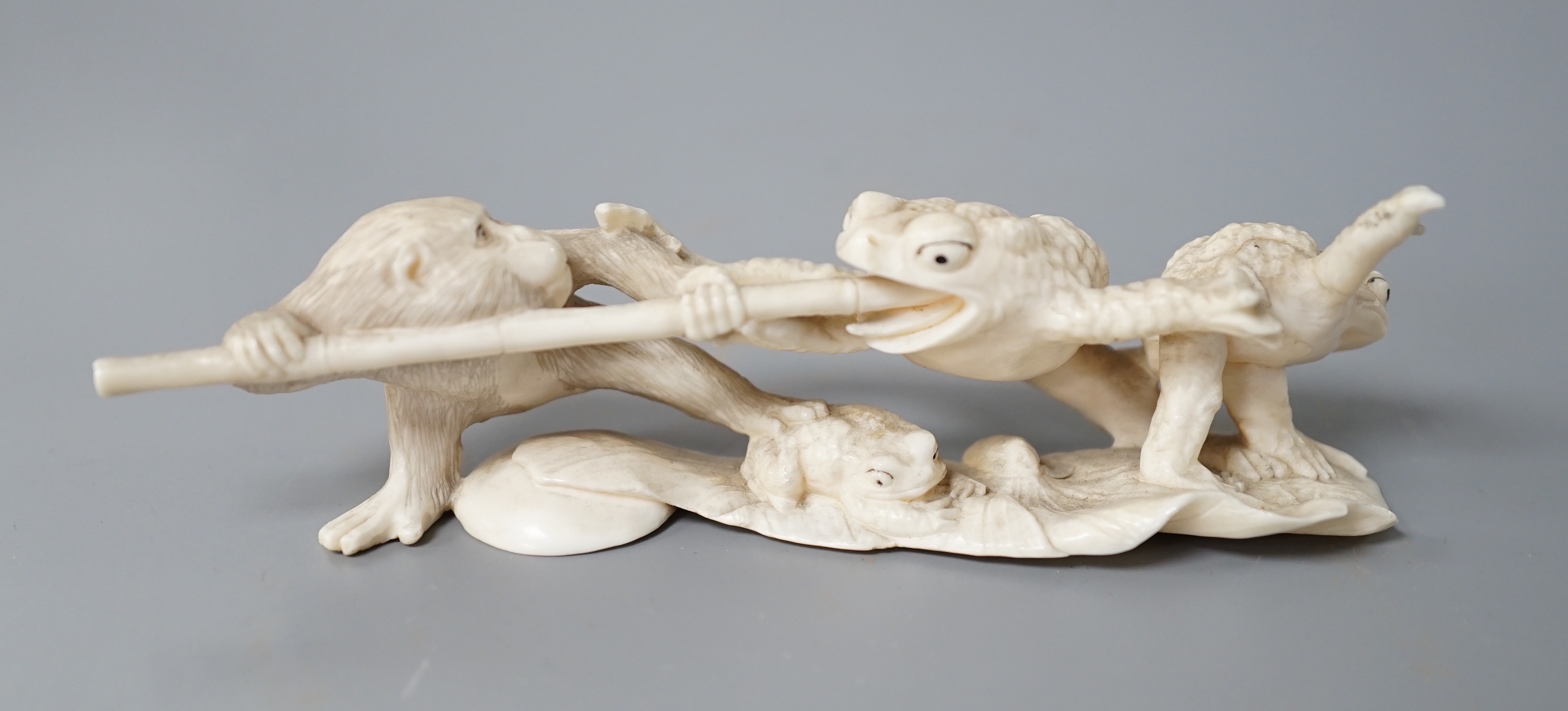 A Japanese ivory okimono of a monkey and toads, Meiji period, 12cm